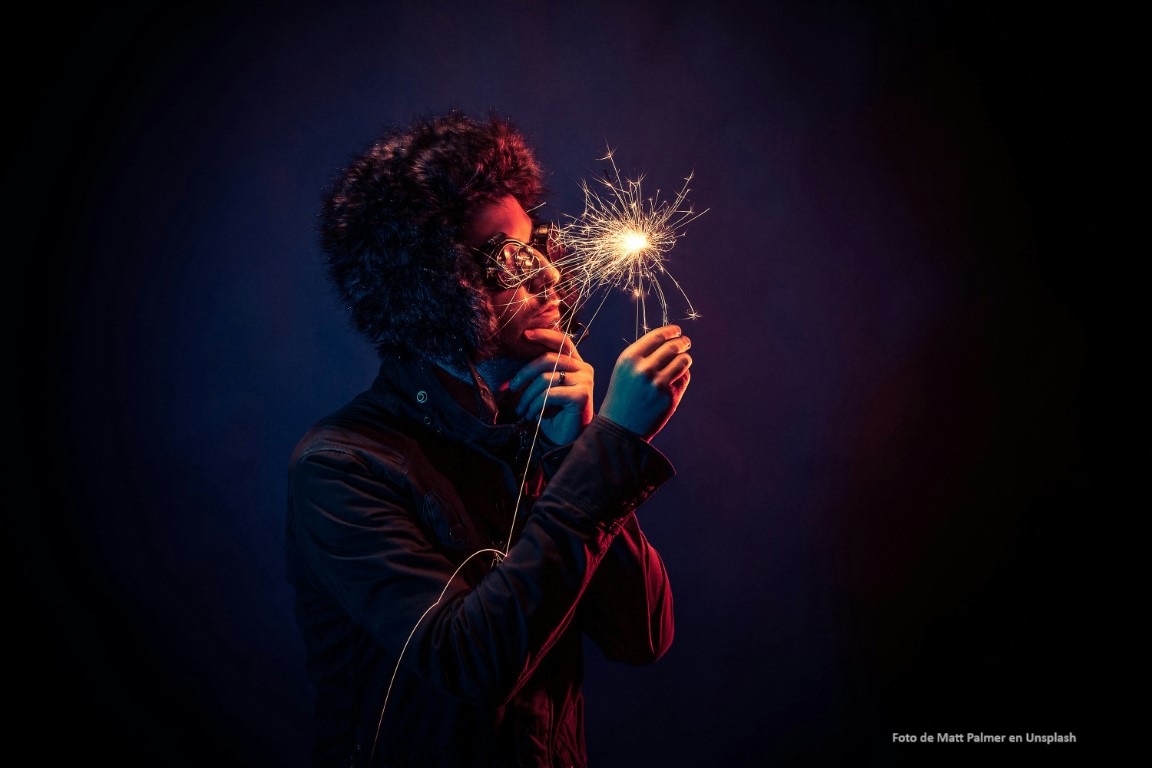 Hombre observa con curiosidad una bengala de luz que sostiene en su mano